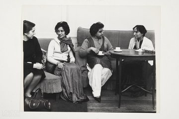 Photo of four individuals sat down on sofas