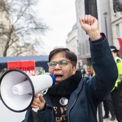 Image of Vandana Aparanti speaking into loudspeaker.